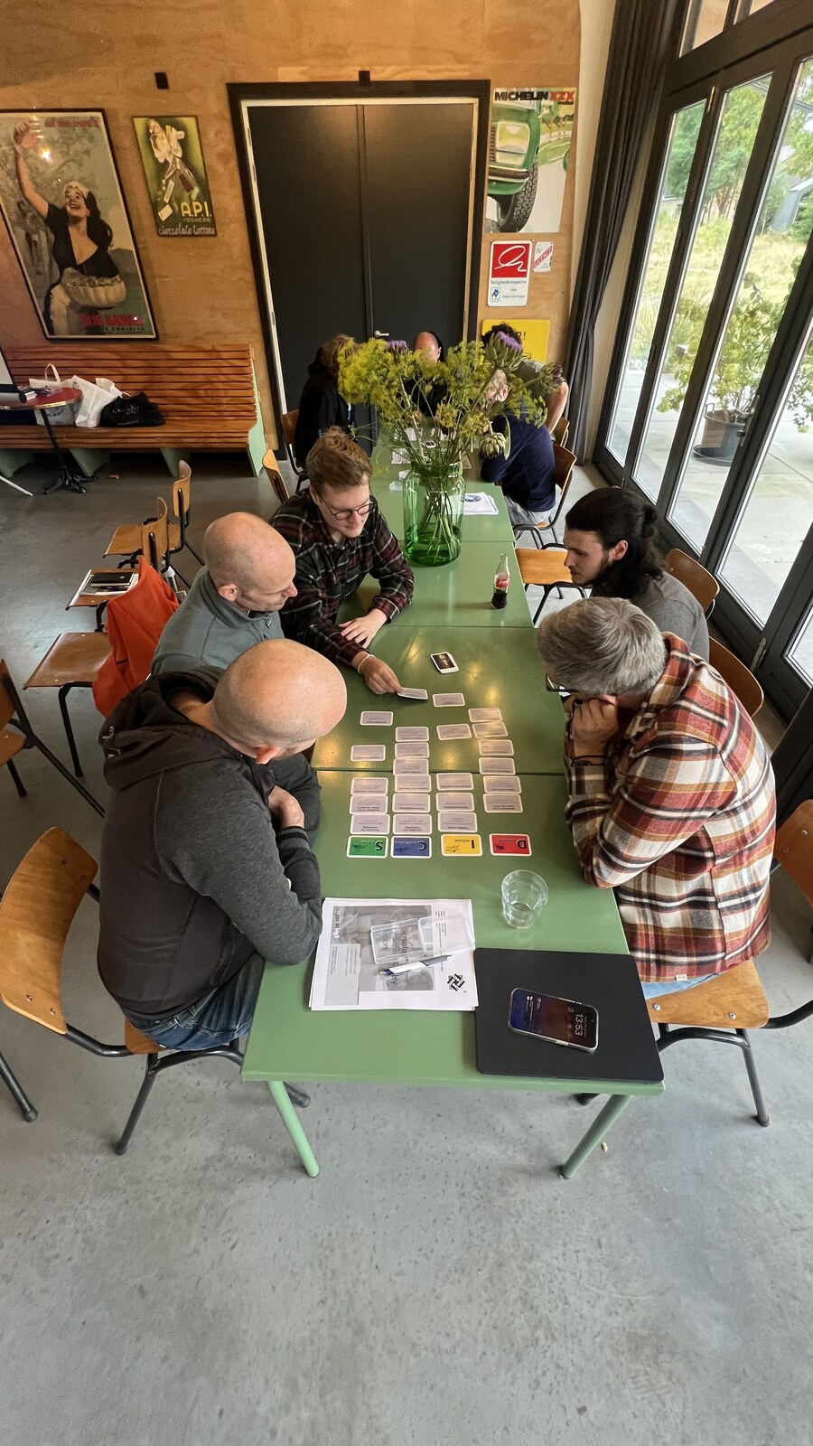 Team werkt samen met kaarten op tafel, top-down perspectief