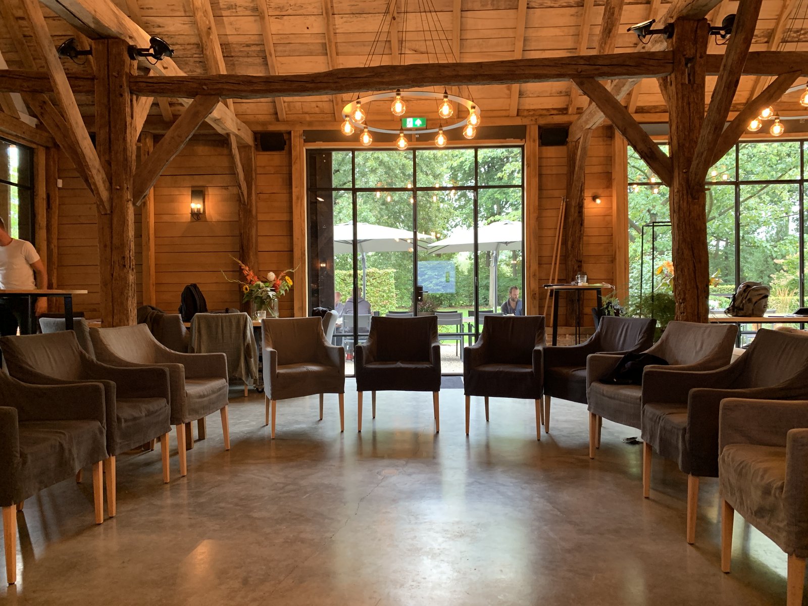 ROOTS Inspiratielocatie in Haaren, open kring van fauteuils onder eikenhouten gebint, daglicht door grote glazen pui